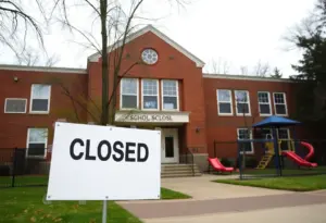 Illustration of a school closure sign in front of an elementary school
